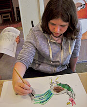 young girl painting a bird