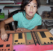 young girl painting pueblo buildings